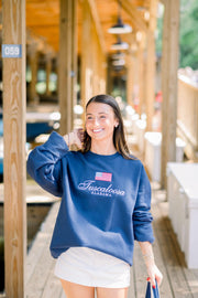 Local Merch Navy Crewneck with an embroidered American Flag above White embroidered text “Tuscaloosa Alabama”