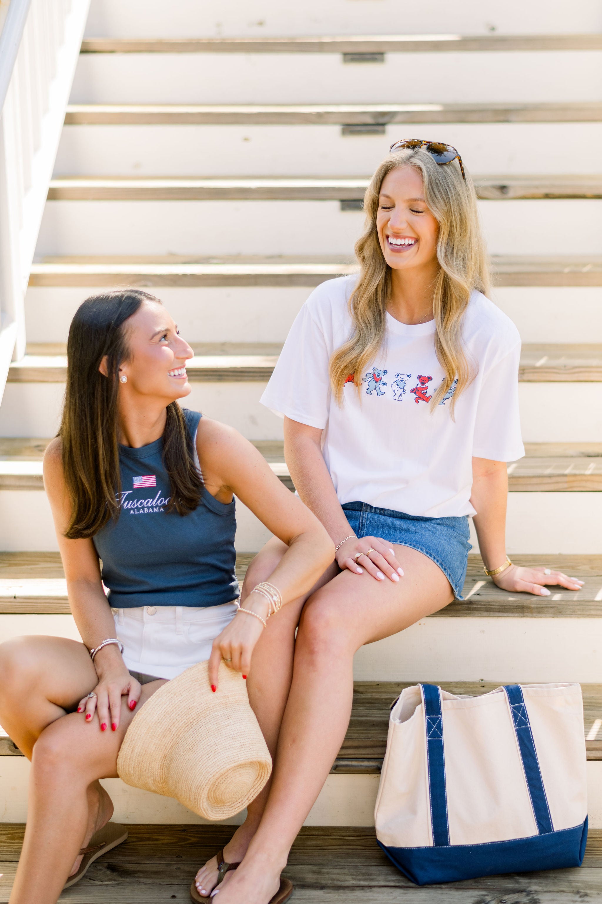 Two women sitting together, one in the Tuscaloosa Americana Tank, the other in the Patriotic Bears T-Shirt
