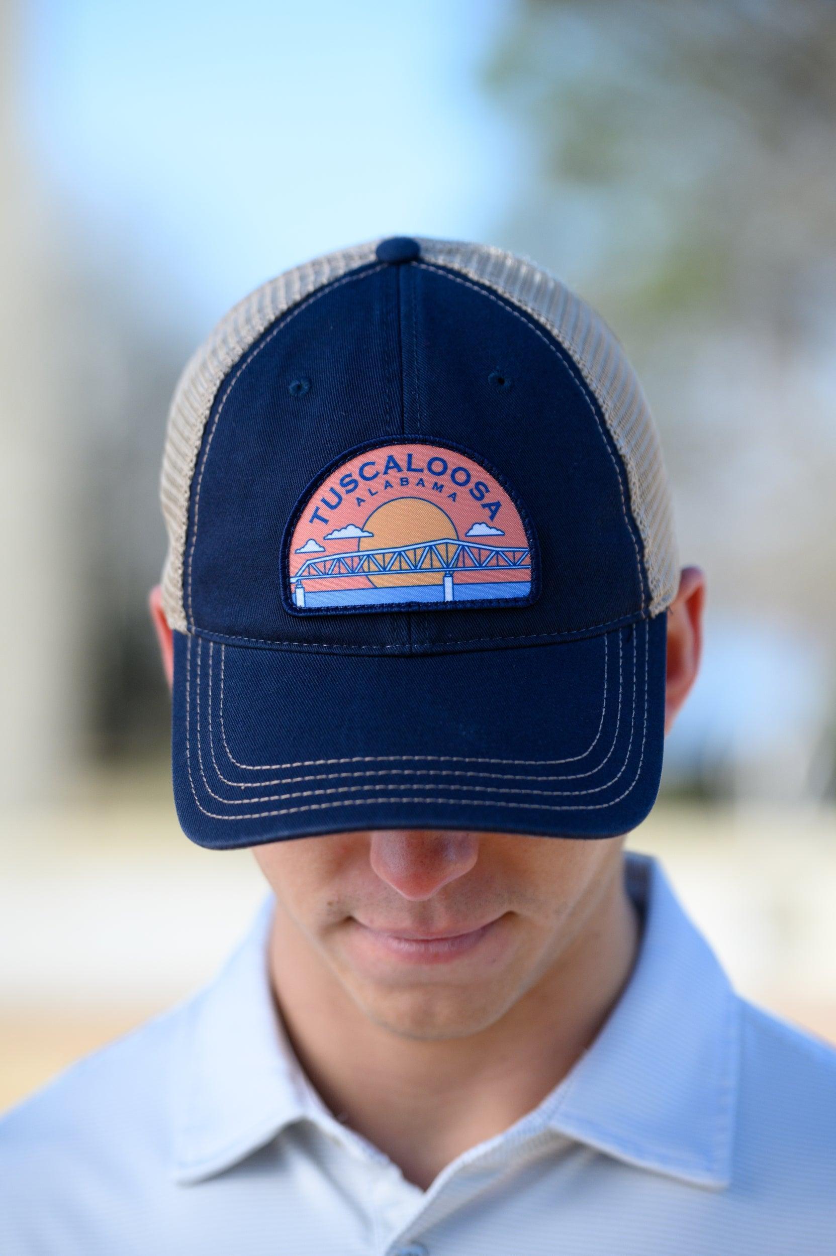 Tuscaloosa Navy and Beige Trucker Hat with a patch featuring Navy text "Tuscaloosa Alabama" a drawing of the sun setting on the iconic Tuscaloosa Railroad Tracks