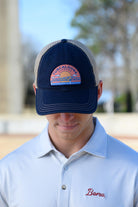 Tuscaloosa Navy and Beige Trucker Hat with a patch featuring Navy text "Tuscaloosa Alabama" a drawing of the sun setting on the iconic Tuscaloosa Railroad Tracks