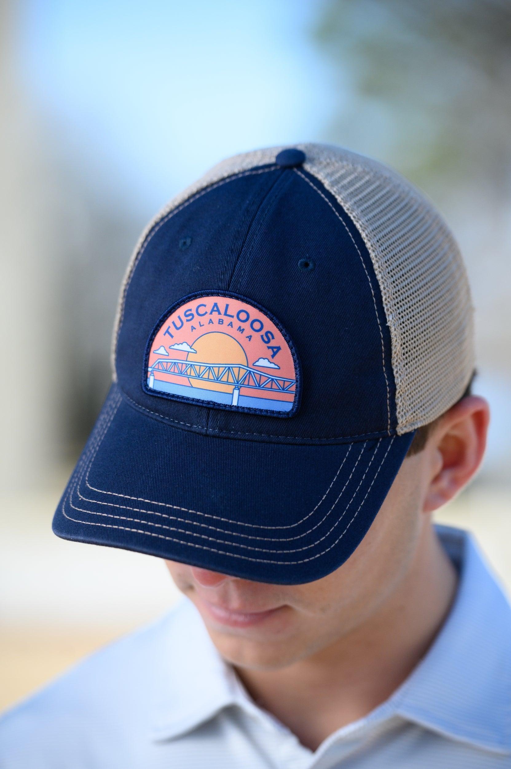 Tuscaloosa Navy and Beige Trucker Hat with a patch featuring Navy text "Tuscaloosa Alabama" a drawing of the sun setting on the iconic Tuscaloosa Railroad Tracks