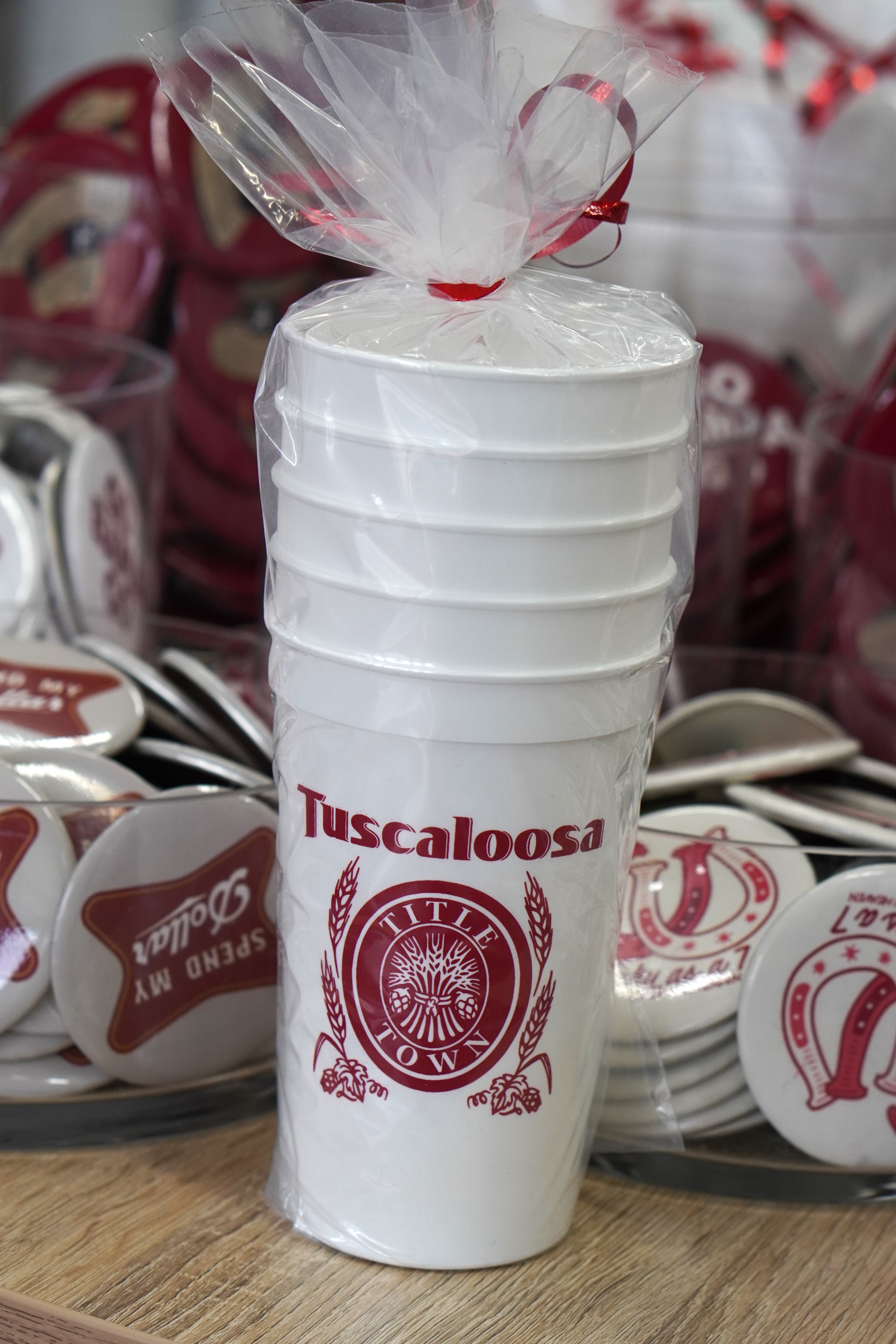 Tuscaloosa White Stadium Cup with Red text "Tuscaloosa" above the Red and White Title Town emblem, a bundle of wheat with the words "Title Town" circling it