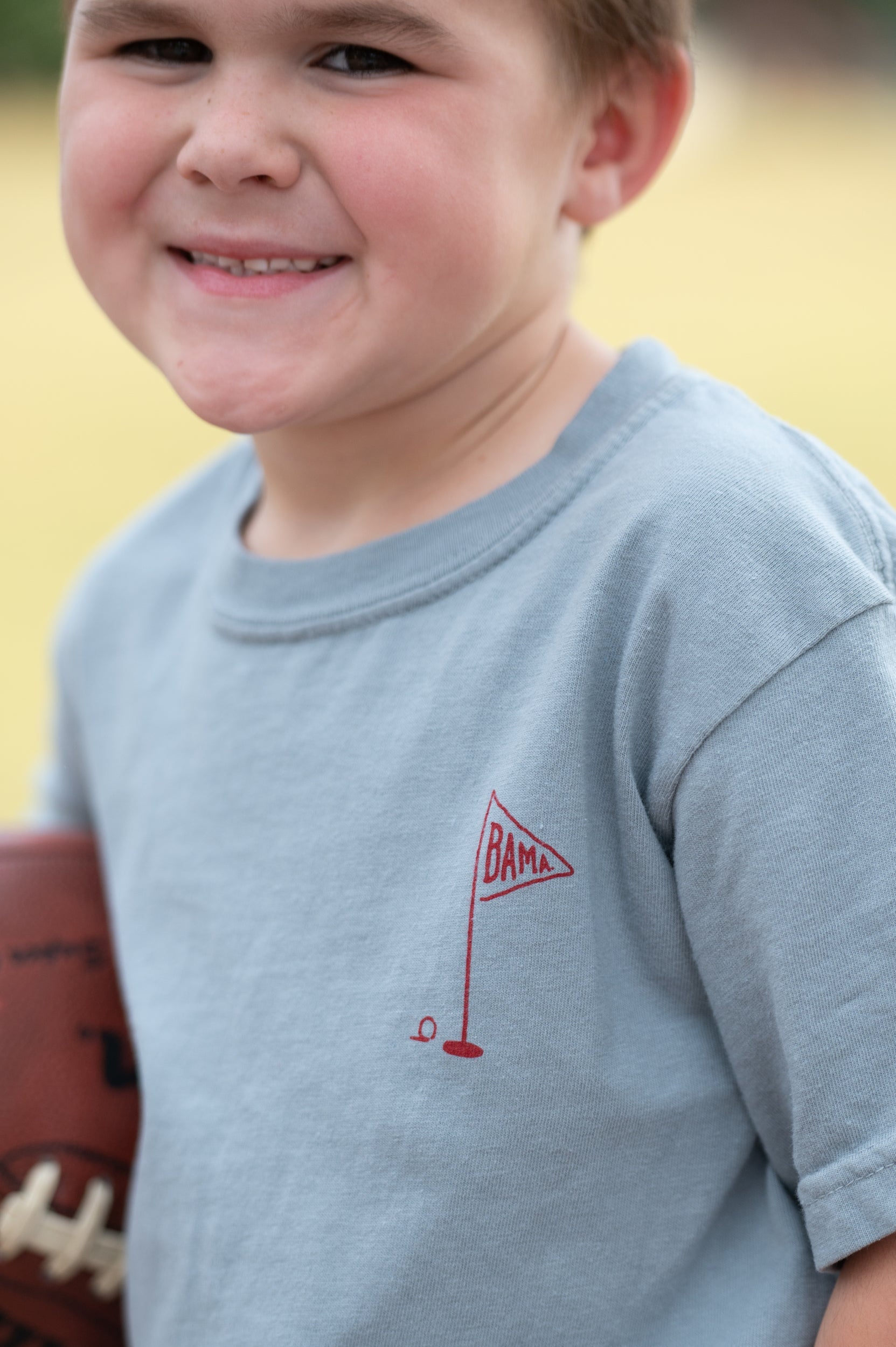 University of Alabama Blue Youth T-Shirt with a small, Red golf flag with "UA" inside