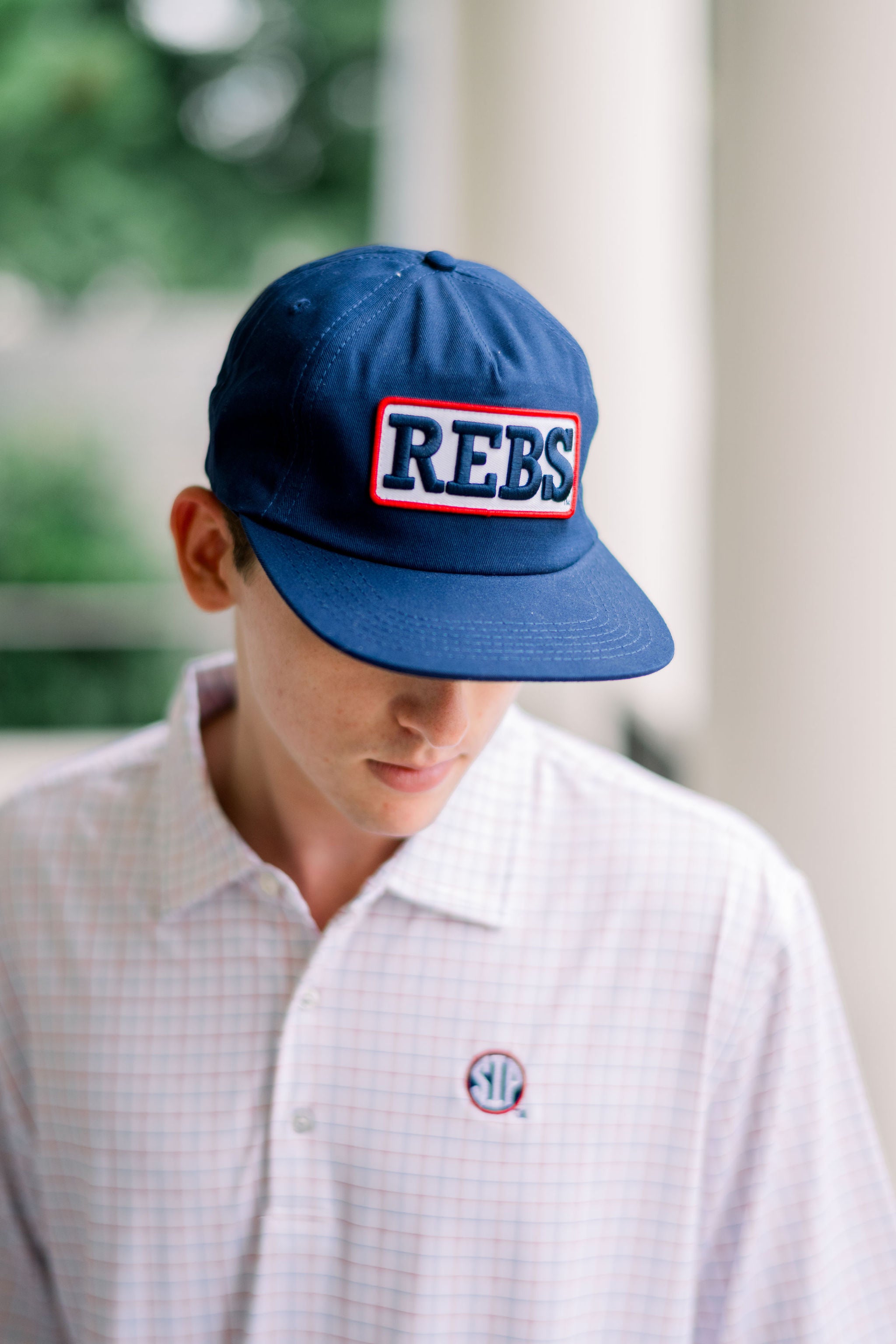 Ole Miss Navy Snapback Hat featuring a White patch with Navy “REBS” embroidery