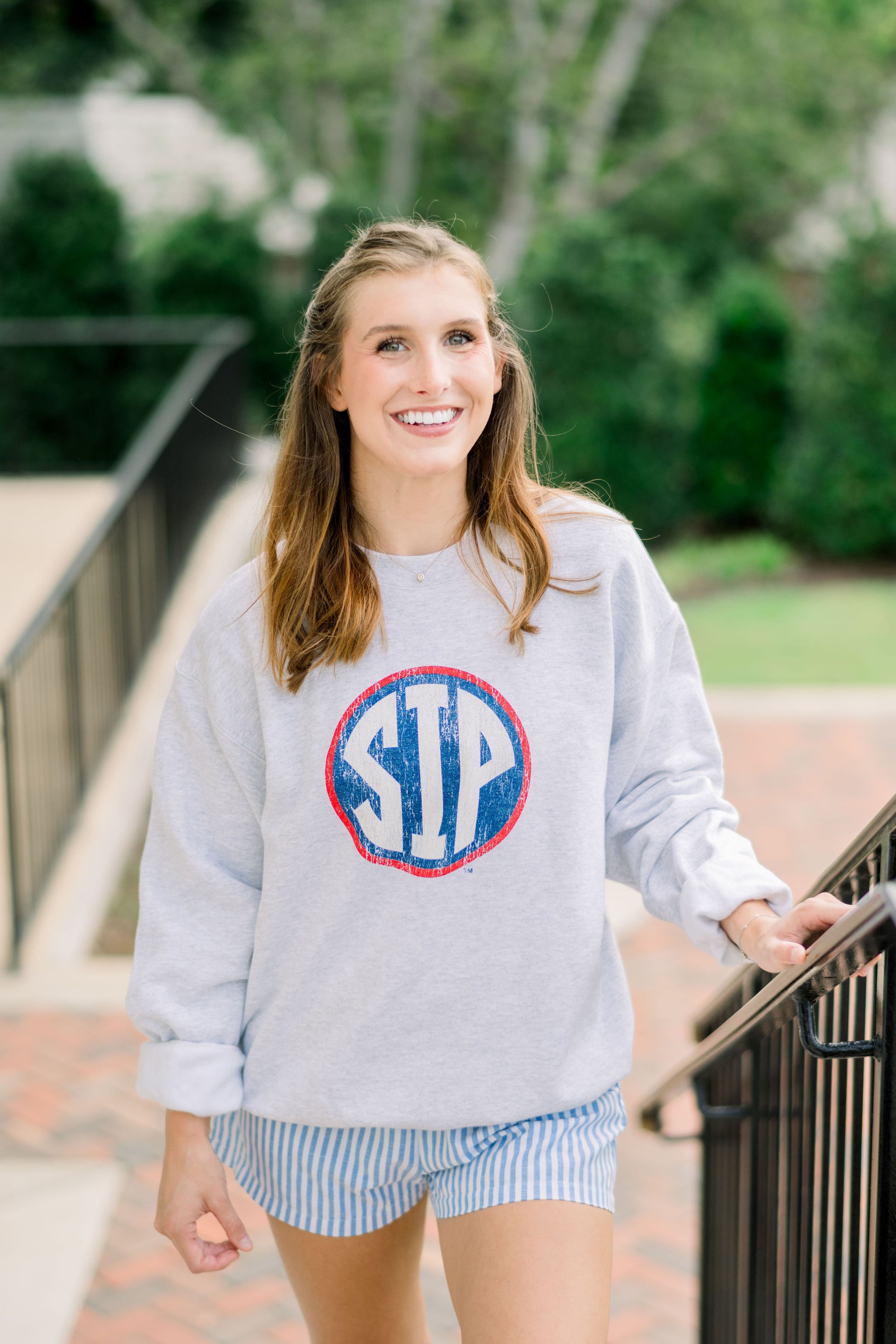 Ole Miss Light Grey Sweatshirt with a Distressed Red outlined Navy circle with White Text “SIP” inside