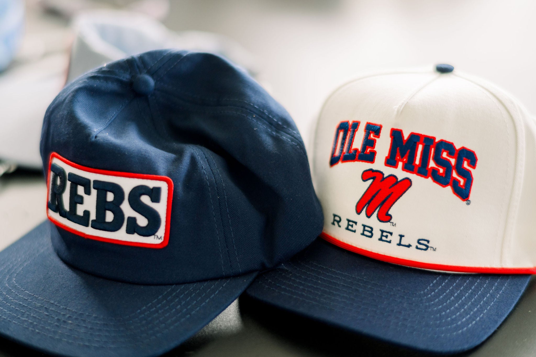 Ole Miss Cream and Navy Hat with embroidered text “Ole Miss Rebels” surrounding the Script M Logo