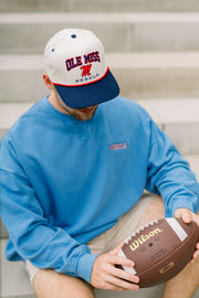 Ole Miss Cream and Navy Hat with embroidered text “Ole Miss Rebels” surrounding the Script M Logo