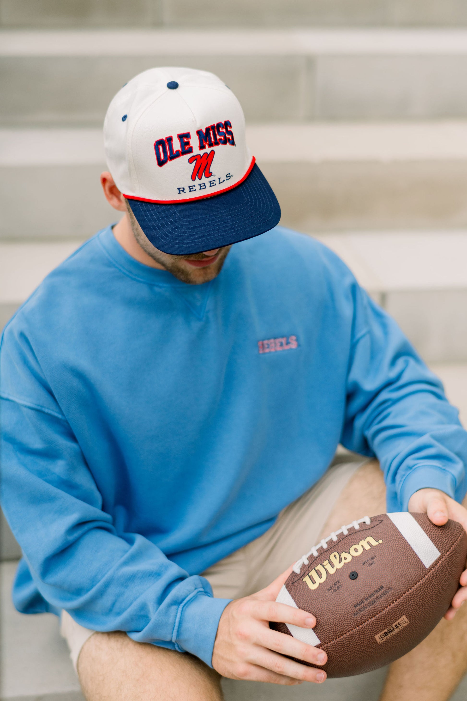 Ole Miss Cream and Navy Hat with embroidered text “Ole Miss Rebels” surrounding the Script M Logo