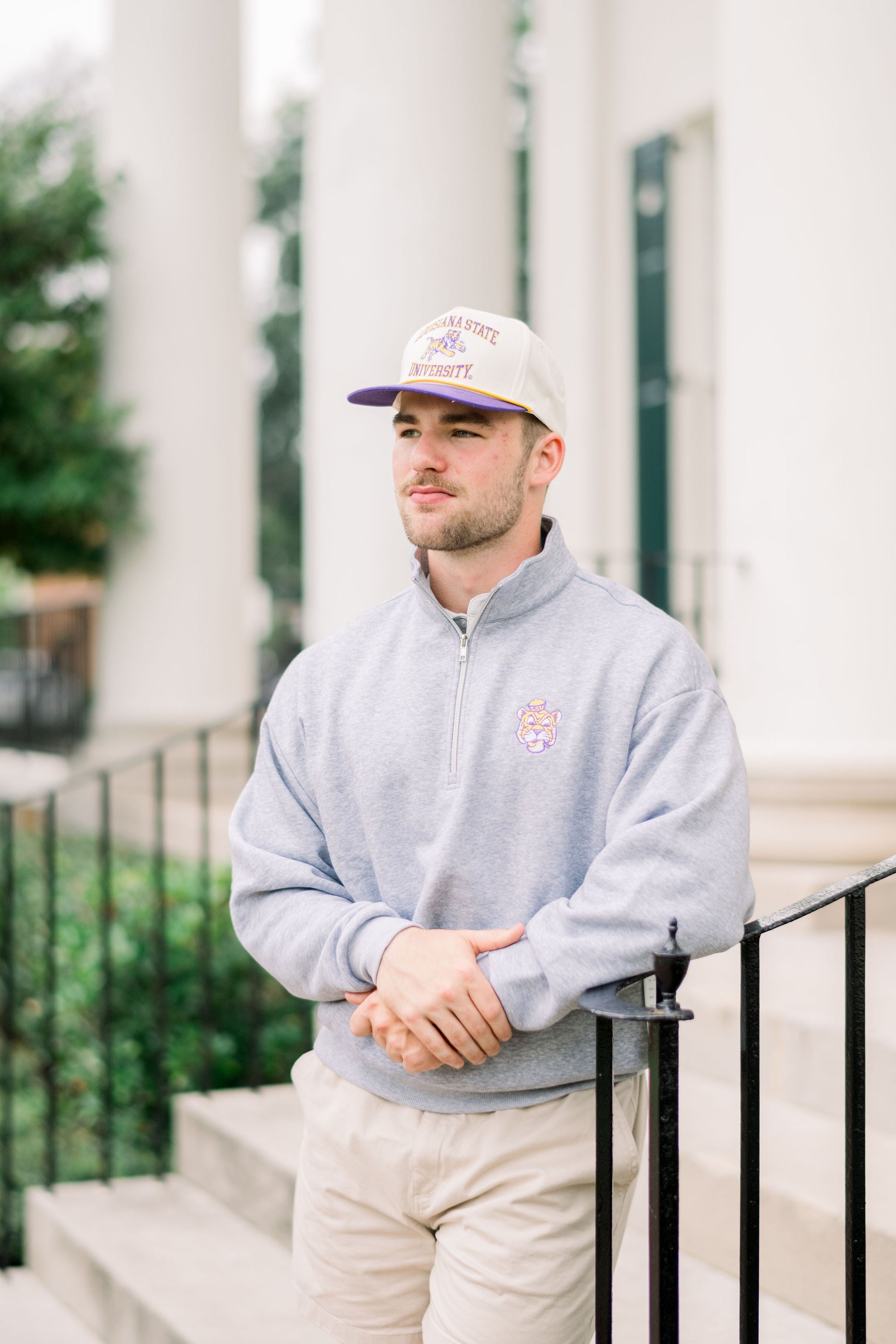 LSU Tan Hat with a Purple brim featuring text “Louisiana State University” surrounding a leaping Bengal tiger 