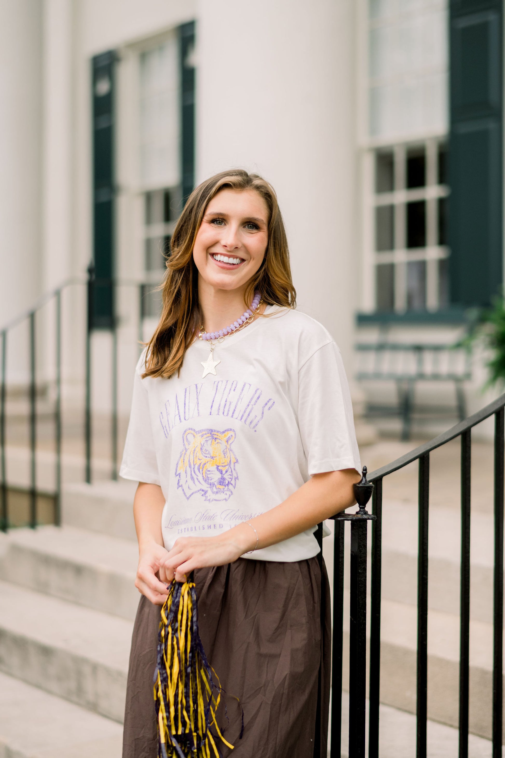 Louisiana State University Ivory T-Shirt with Purple text “Geaux Tigers” above a growling Bengal tiger