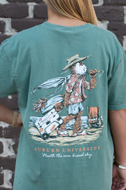 Auburn University Aubie Beach Green Comfort Colors T-Shirt with an image of Aubie the Tiger in beach clothes carrying an umbrella dragging a cooler across the sand