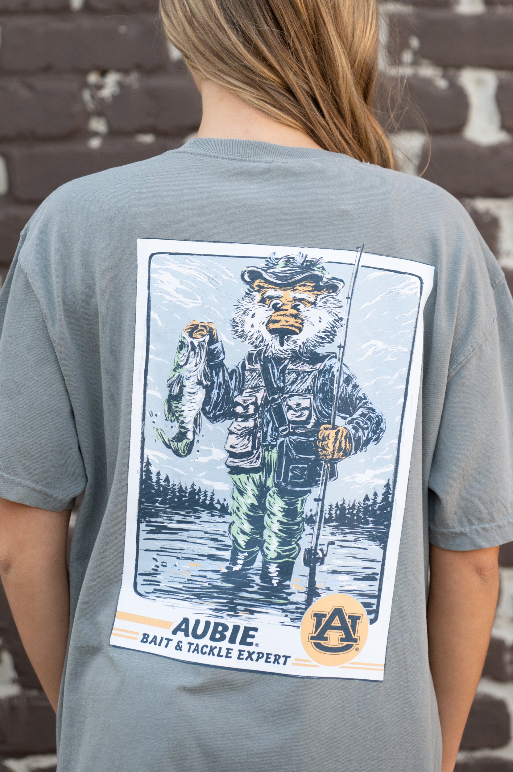 Auburn University Aubie Fishing Comfort Colors Grey T-Shirt with image of Aubie standing in the water holding a fishing pole