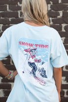 University of Alabama Big Al Snow Skiing Chambray Comfort Colors T-Shirt with text "Snow Tide" above an image of Big Al in a ski outfit skiing down a snow-covered mountain